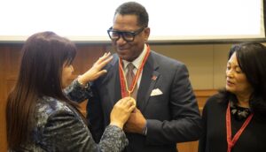 Rutgers University–Camden Chancellor Antonio D. Tillis receives a medallion from Zully Vera de Molinas, rector of UNA, as Gloria Bonilla-Santiago, Distinguished Board of Governors Professor, looks on.