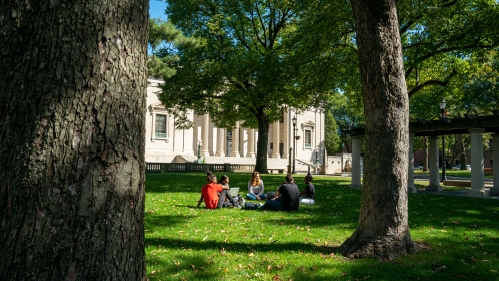 Students sitting on grass in front of Johnson Park